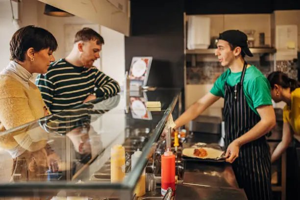 Regular customers chatting over lunch at the deli counter