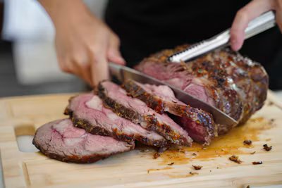 Deli slicer cutting thin slices of roast beef